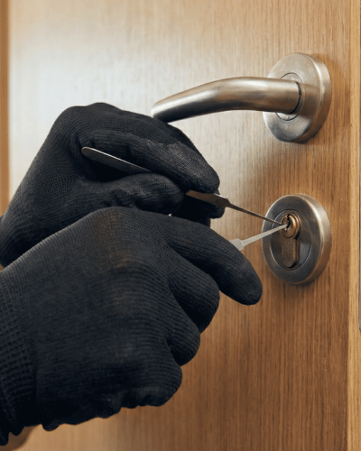 Gros plan sur les mains d'un serrurier ouvrant une serrure avec précision, illustrant une ouverture de porte sans casse.